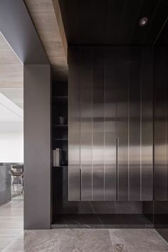 an empty kitchen with stainless steel cabinets and marble flooring