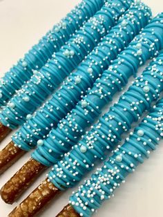 blue and white decorated cookies are arranged in the shape of sticks with sprinkles on them