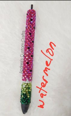 the pen is decorated with multicolored beads and sparkles on it's tip