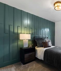 a bedroom with green paneled walls and a bed