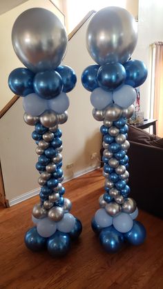 two tall blue and silver balloons on top of each other in the shape of columns