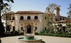 a large house with a fountain in front of it