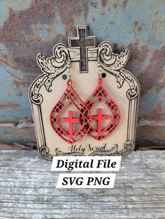 a pair of red and black earrings on top of a wooden table with the words digital file svg png