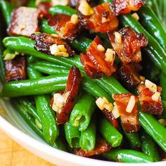 a white bowl filled with green beans and bacon