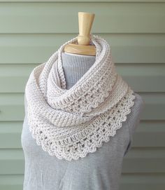 a white crocheted scarf is on a mannequin