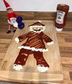 a wooden cutting board topped with chocolate frosting and an image of a gingerbread man