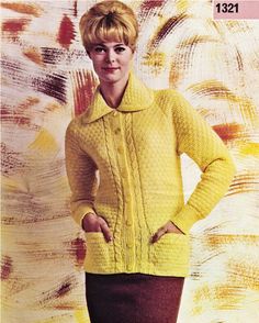 a woman standing in front of a painting wearing a yellow sweater and brown pencil skirt