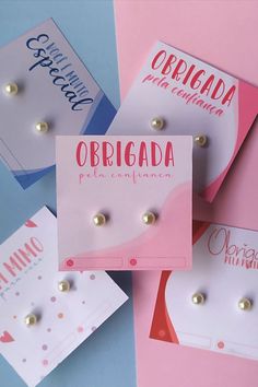 four different types of earrings on pink and blue paper with words written in spanish above them