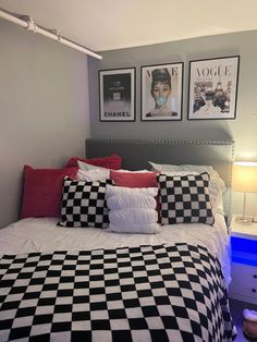 a black and white checkered bedspread on a bed in a room with pictures above it