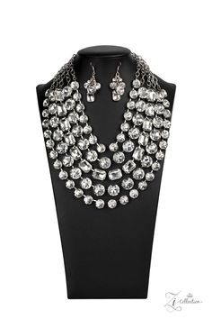 a necklace and earring set on a mannequin with crystal stones in the center