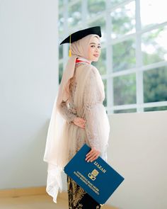 a woman wearing a veil and holding a blue folder