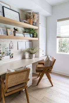 a home office with wooden chairs and shelves filled with books, pictures, and plants