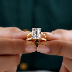 a person holding an engagement ring in their hands