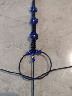 a close up of a beaded object on the ground with wires attached to it