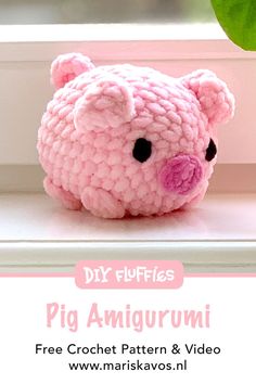 a pink crochet pig stuffed animal sitting on top of a window sill