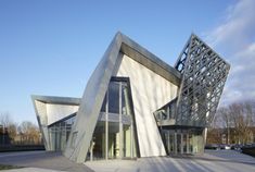 an unusual building that is made out of concrete and glass with a triangular design on the front