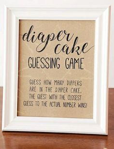 a framed sign that says diaper cake guesting game on the side of a wooden table