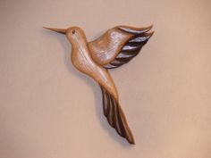 a wood carving of a bird flying in the air