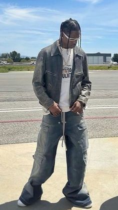 a man standing on top of an airport tarmac with his hands in his pockets