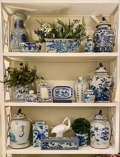 blue and white vases are sitting on the shelves