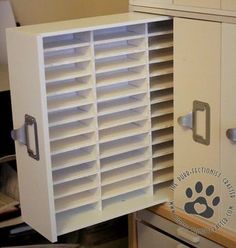 a white cabinet that has some drawers in it and a paw print on the door