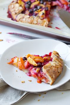 a slice of fruit pie on a plate with a serving utensil next to it