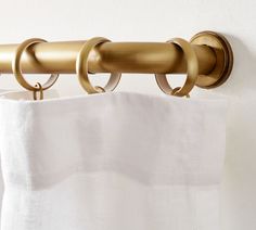 a curtain with two rings hanging from it's side next to a white wall