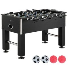 a foosball table with three soccer balls in front of it and four other accessories