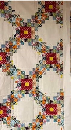 an old quilt is hanging on the wall