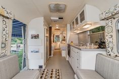 the inside of a camper with couches, cabinets and kitchen area in it