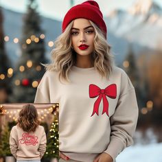 Spread holiday cheer in our cozy and cute Merry Christmas red bow sweatshirt. Look festive and fashionable for all your holiday activities this season. This sweatshirt features a cute red bow on the front and Merry Christmas printed on the back. Makes great group photos, Christmas pajama tops and gifts for all the fashionable Christmas girls!  A sturdy and warm sweatshirt bound to keep you warm in the colder months. A pre-shrunk, classic fit sweater that's made with air-jet spun yarn for a soft Womens Red Sweater, Bow Sweatshirt, Womens Christmas Shirts, Trendy Hat, Cozy Holiday, Christmas Bow, Etsy Christmas, Holiday Sweater, Christmas Bows