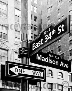 black and white photograph of street signs in new york's east 34th st