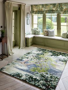 a large rug in the middle of a room with green walls and window sill