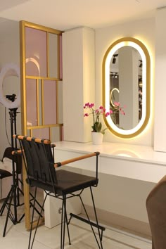 a chair sitting in front of a mirror next to a table with flowers on it