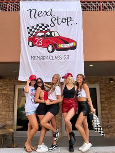 four girls are posing in front of a sign that says next stop member class 23