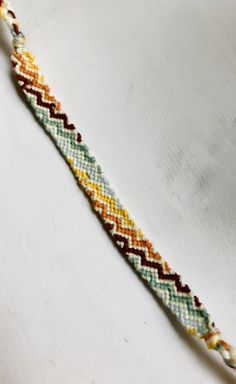 a colorful bracelet is laying on a white surface