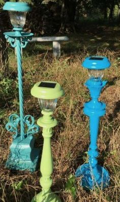 three blue and green street lights sitting in the grass