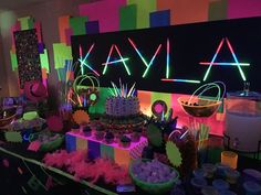 an image of a birthday party with neon lights and cake on the table in front of it