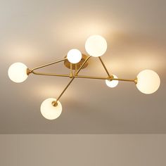 a ceiling light that has five lights on it and four balls hanging from the ceiling