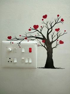 a light switch cover with a tree and hearts painted on it