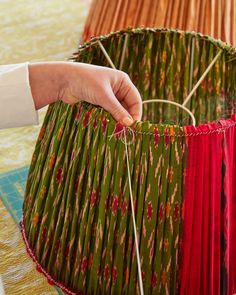 a person is making a lamp shade with yarn