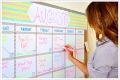 a woman writing on a white board with sticky notes