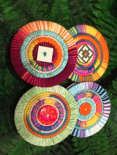 four colorful paper plates sitting on top of green grass