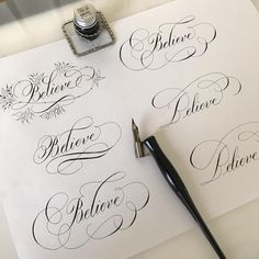 some type of calligraphy on top of a piece of paper next to a fountain pen