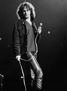 a man holding a microphone while standing on stage