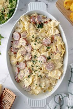 a white bowl filled with pasta and sausage