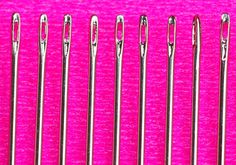 several pairs of scissors are lined up against a pink background