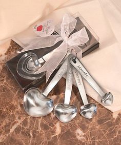 spoons and measuring spoons tied together in a bow on top of a table