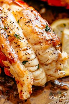 a close up of a chicken on a plate with lemon wedges and seasoning