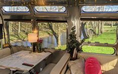 the inside of a camper with lots of windows and couches in front of it